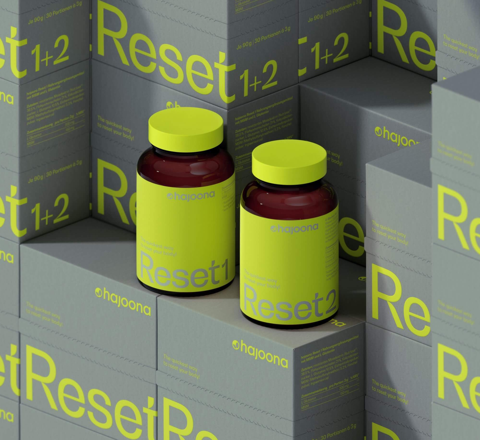 Zwei braune Glasbehälter mit neonfarbenem Etikett und Deckel, beschriftet mit "Reset 1" und "Reset 2" von hajoona. Die Flaschen stehen auf gestapelten Produktkartons mit der Aufschrift "Reset 1+2" in leuchtendem Grün auf grauem Hintergrund. Modernes, minimalistisches Verpackungsdesign.